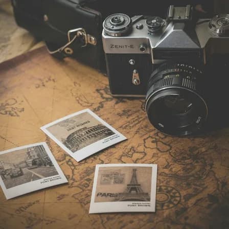 A camera and printed photographs arranged on a creative workspace.